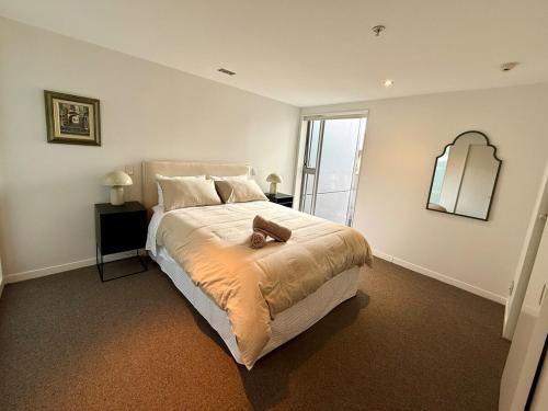 a bedroom with a bed with a teddy bear on it at Prime 3 bedrooms apartment with harbour views in Wellington Central in Wellington