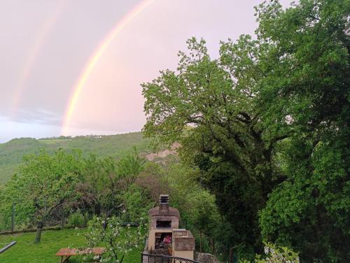 a rainbow in the sky over a house with trees at Il Poggio b&b-appartamento in San Marino
