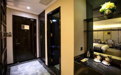 a room with a bathroom with a mirror and a bed at Shantou Grandtide Hotel in Shantou