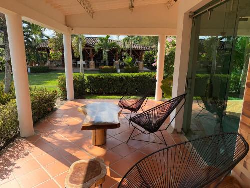 a patio with chairs and a table and a bench at Yopo Resort - Suite Yopal in Yopal