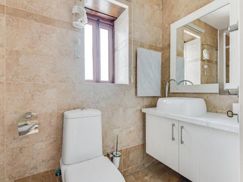a bathroom with a toilet and a sink and a mirror at Sanders Arsorama Arsos in Arsos