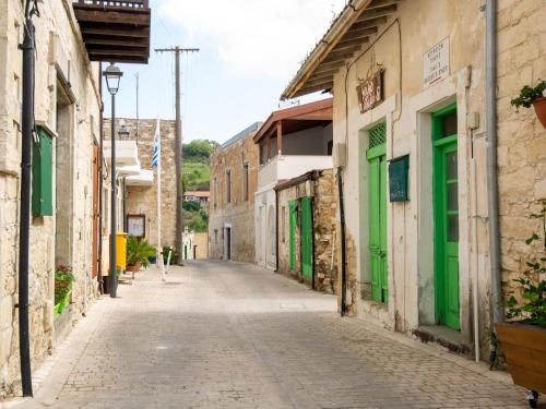 an empty street in an old town with green doors at Sanders Arsorama Arsos in Arsos