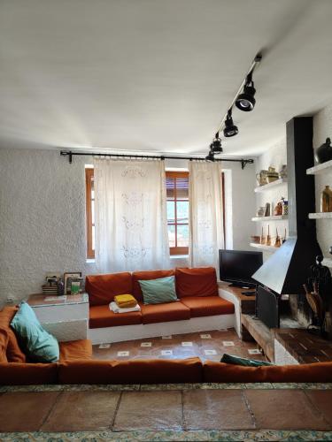 a living room with a couch and a television at Casa rural entera en Parque Natural de los Puertos in Alfara de Carles
