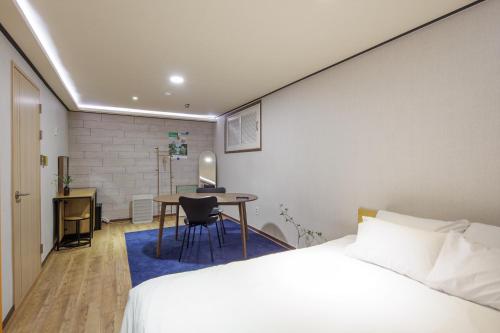a bedroom with a bed and a desk and a table at LEBROWN Stay in Seoul