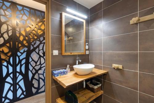 une salle de bain avec un lavabo et un miroir dans l'établissement Cabana & Alp'évasion - Pools, Sauna, Pool Table, à Samoëns
