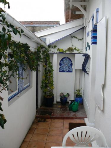 une cour avec des plantes en pot dans un bâtiment blanc dans l'établissement Villa des trois Statues, à Arcachon