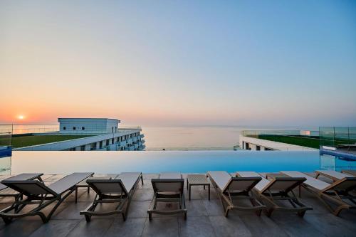 una piscina con mesas y sillas en la azotea de un edificio en Dream luxury apartments in Infinity pool Spa resort, en Mamaia