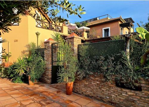 a house with a brick wall with plants on it at Vrachokipos in Souvala
