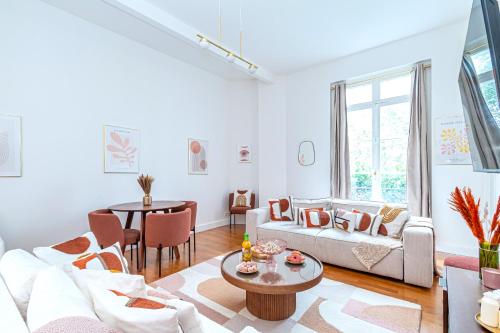 un salon avec un canapé et une table dans l'établissement Appartement raffiné - Arc de Triomphe, à Paris
