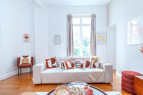 un salon avec un canapé et une fenêtre dans l'établissement Appartement raffiné - Arc de Triomphe, à Paris