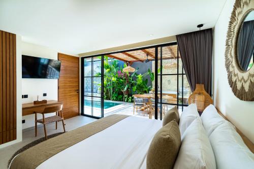 a bedroom with a large white bed and a desk at 2BR Pool Rooftop Villa in Seseh with 5 minutes Ride to Beach Staff in Canggu