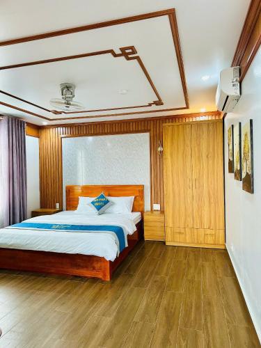 a bedroom with a large bed and wooden floors at Hải Phát Hotel in Thái Nguyên