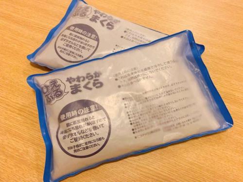 two packages of food sitting on a wooden table at Dormy Inn Premium Namba Natural Hot Spring in Osaka