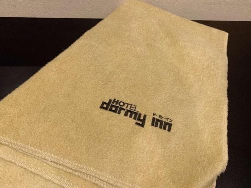 a towel with the words hirschuth inn on it at Dormy Inn Premium Namba Natural Hot Spring in Osaka