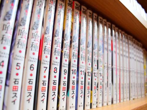 a row of books sitting on a book shelf at Dormy Inn Premium Namba Natural Hot Spring in Osaka