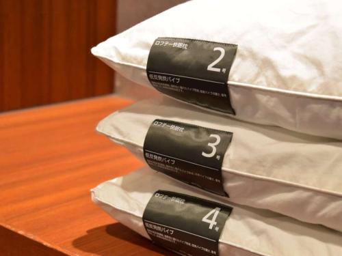 three black and white pillows on a table at Dormy Inn Premium Namba Natural Hot Spring in Osaka