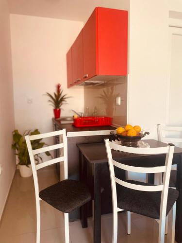 a kitchen with a table with two chairs and red cabinets at Vila Biser in Veliko Gradište