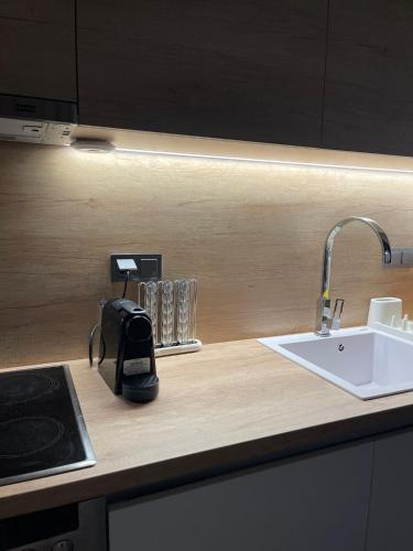 a kitchen counter top with a sink and a kitchenilit at Andromachi's House in Pefkochori