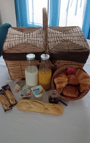una cesta de pan y leche y una cesta de pan en Chambre d'hôtes, en La Lande