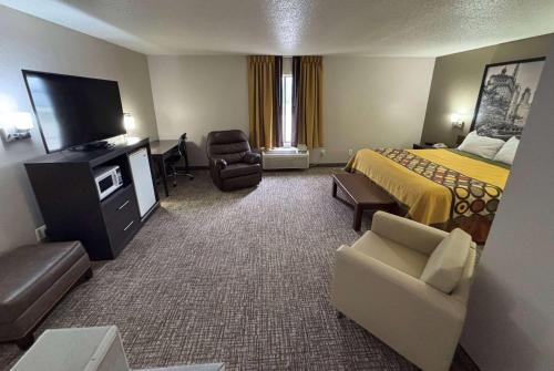 a hotel room with a bed and a flat screen tv at Super 8 by Wyndham Marshall in Marshall