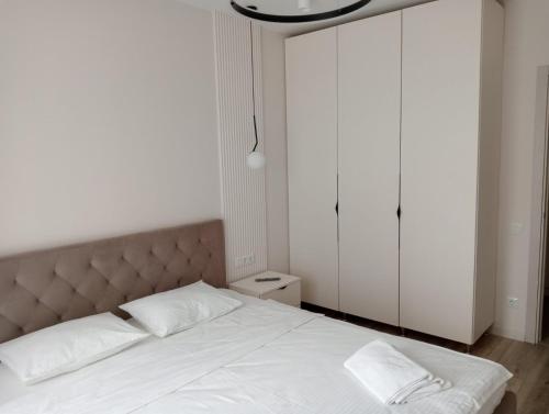 a bedroom with a large bed with white sheets at Люкс залізничний вокзал in Luts'k