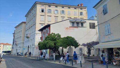 a group of people walking down a street in front of a building at Casa Lumina - new 2025 in Piran