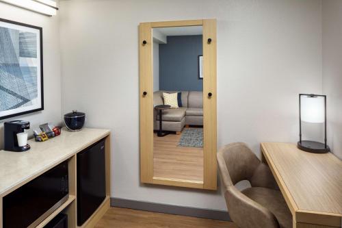 a living room with a mirror and a chair at Hyatt Place Lake Mary/Orlando North in Lake Mary