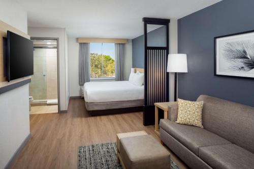 a hotel room with a bed and a couch at Hyatt Place Lake Mary/Orlando North in Lake Mary