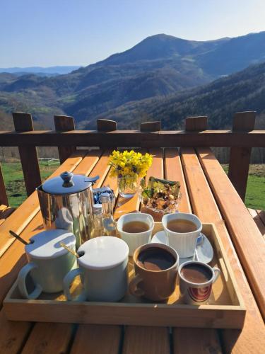 a tray with cups of coffee on a wooden table at Kamp Kruščić - Laništa in Mojkovac