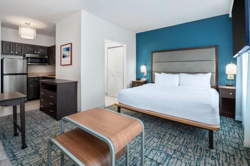 a hotel room with a bed and a kitchen at Homewood Suites by Hilton Eatontown in Eatontown
