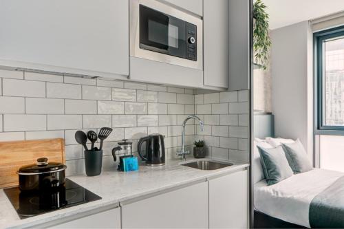 a kitchen with a sink and a microwave at ARK Canary Wharf in London
