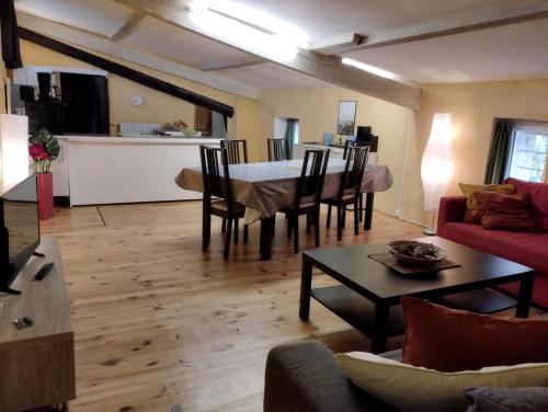 a living room with a table and a kitchen at Le Moulin Des Ocres in Apt
