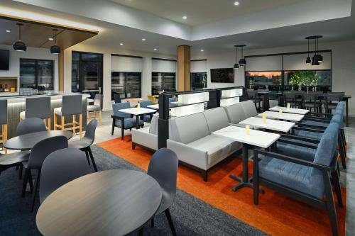 a restaurant with tables and chairs and a bar at Hyatt House Auburn Hills/Detroit in Lake Orion