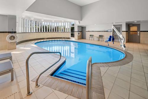 a large swimming pool in a hotel lobby at Spark By Hilton Woodbridge in Woodbridge