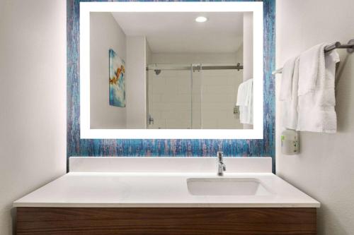 a bathroom with a white sink and a mirror at La Quinta Inn & Suites by Wyndham Austin South in Austin