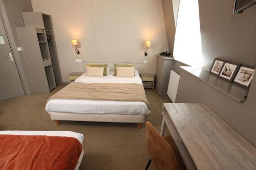 a hotel room with a bed and a table and a table sidx sidx at Cit'Hotel Les Alizes in Dinard