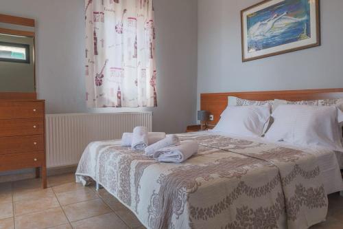 a bedroom with a bed with towels on it at SeaView House Nikiti in Nikiti