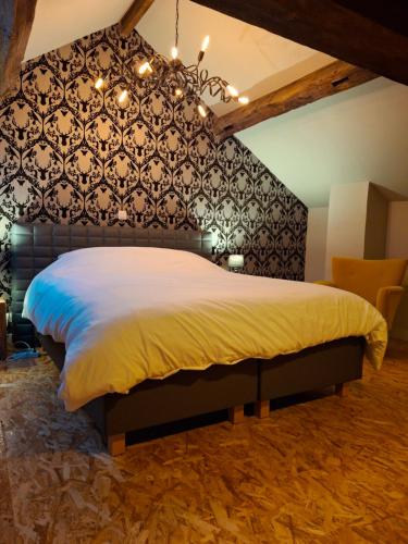 a bedroom with a large bed with a black wall at Label Semois Gite rural 3 épis in Bouillon