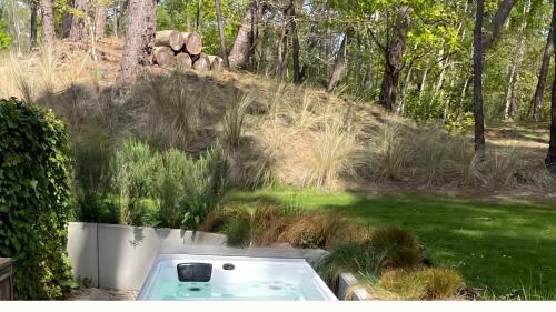 a bath tub in a yard with grass and trees at Villa Brigitte in Le Touquet-Paris-Plage