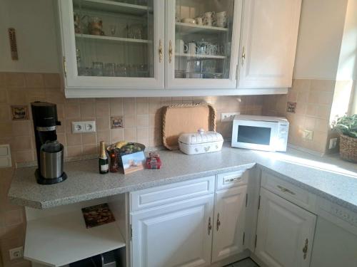 a kitchen with white cabinets and a microwave at Ferienhaus-Sophie in Diekhusen-Fahrstedt