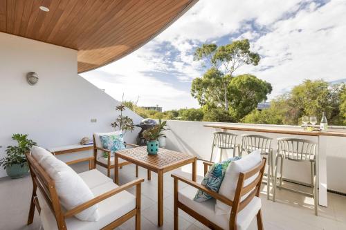 a room with a balcony with chairs and a table at Salty Solstice-Beachside Dunsborough Town in Dunsborough