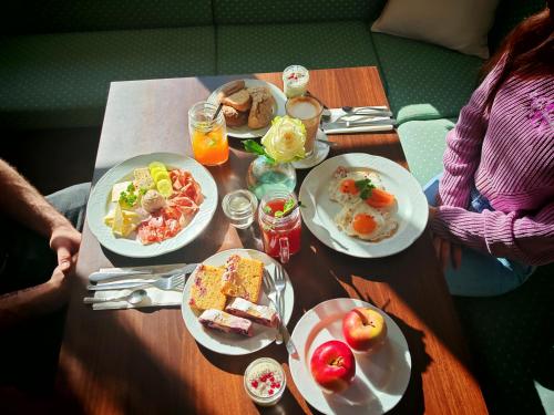 a table with plates of breakfast food on it at Pohorje Village Wellbeing Resort - Forest Hotel Videc in Pohorje