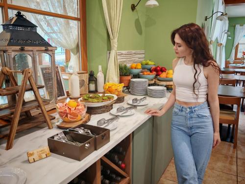 a woman standing at a counter in a kitchen at Pohorje Village Wellbeing Resort - Forest Hotel Videc in Pohorje