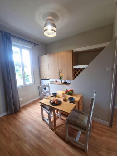 une cuisine avec une table et des chaises dans une pièce dans l'établissement L'escale saint saint brévin les pins, à Saint-Brévin-les-Pins