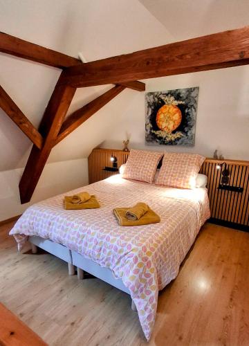 a bedroom with a bed with two towels on it at O' Bulles du Rosenbourg in Sigolsheim