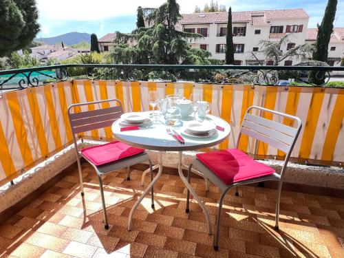 une table et deux chaises sur un balcon dans l'établissement Le Provence 28m2 Lecques Parking-400m Plage Mer, à Saint-Cyr-sur-Mer