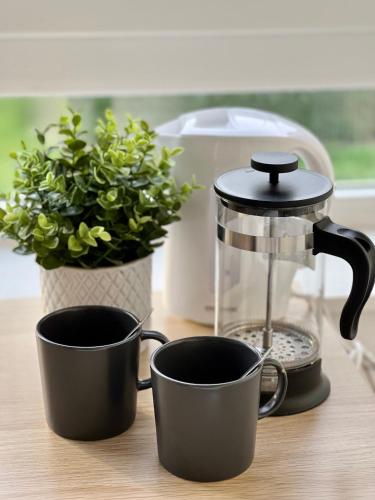 une cafetière et deux tasses sur un comptoir dans l'établissement Le Saint Martin, Rennes Nord, à Rennes