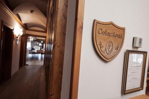 a wooden sign on a wall next to a hallway at Gaarten Hotel Benessere Spa by Kleos Group Collection in Gallio