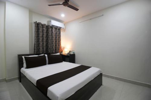 a bedroom with a black and white bed and a window at Collection O Stayo in Hyderabad