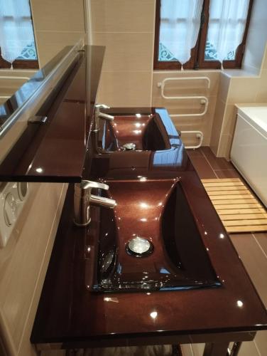 La salle de bains est pourvue d'un lavabo brun. dans l'établissement La Maison d'à Côté, à Saint-Amand-en-Puisaye